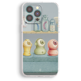 a phone case with a colorful illustration of three small, cartoonish-looking objects arranged on a shelf.